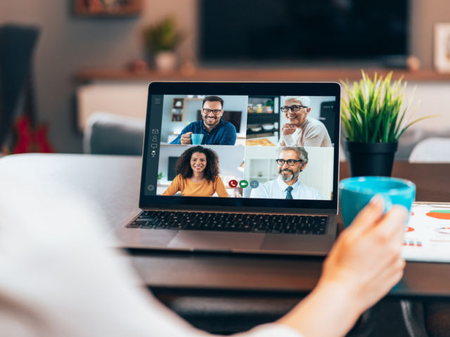 5 Ways to Improve Company Culture Image: Photo of someone sitting at desk with laptop open. There are four people on the screen wearing business attire.