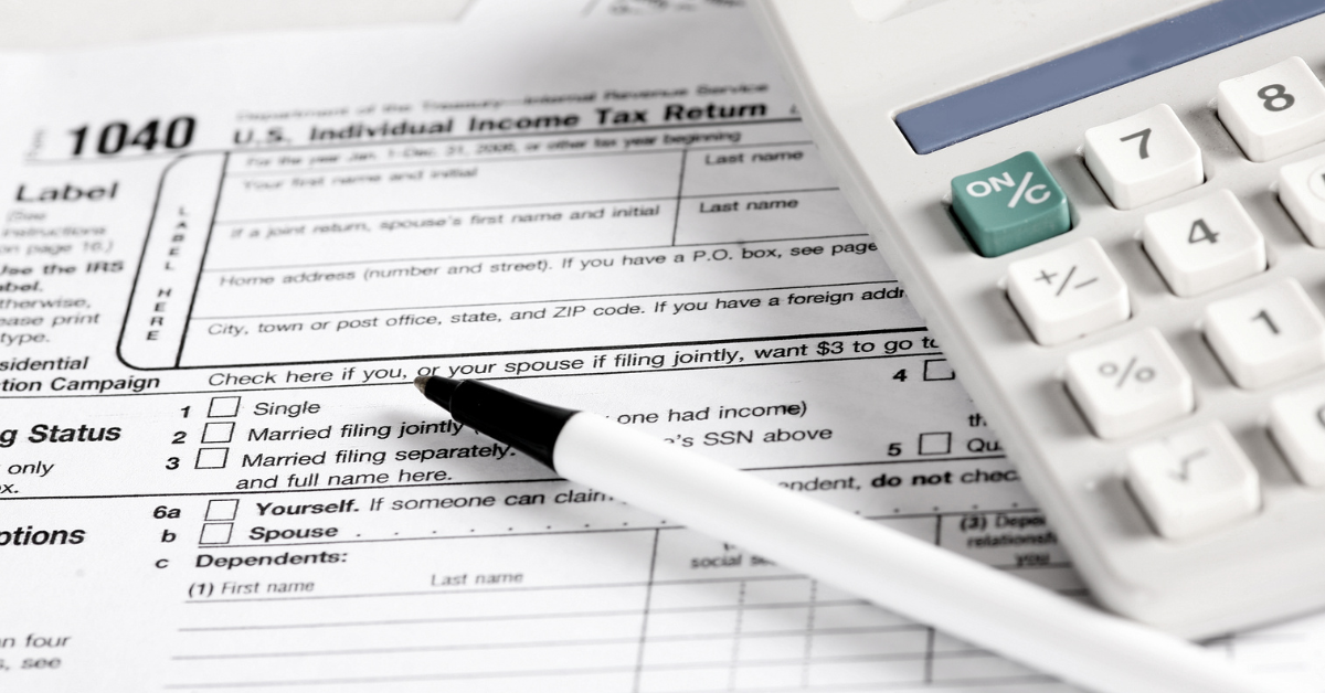 Contract Work Taxes Blog Graphic that is a photo of a 1040 form with a pen and calculator laying on top of it.
